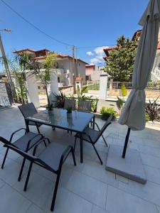 a table and chairs and an umbrella on a patio at Minas Luxury Studios in Stavros