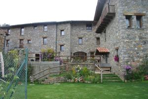 a large brick building with a staircase in the yard at Els Torrents in Bellver de Cerdanya 