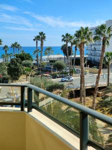 a balcony with a view of the beach and palm trees at Albir Beach & Sun Apt in Albir