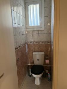 a bathroom with a toilet with a black seat and a window at Appartement entier Velodrome in Roubaix +10 photos