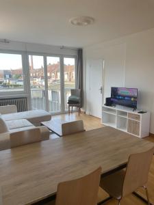 a living room with a table and a couch at Appartement entier Velodrome in Roubaix