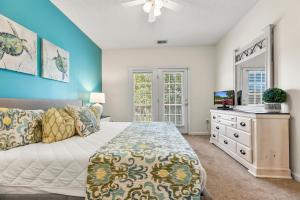 a bedroom with a bed and a dresser with a tv at Charming 3-Bedroom Cherry Grove Condo in Myrtle Beach +24 photos