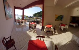 a restaurant with tables and chairs and a balcony at Hotel Guarakessaba in Guaraqueçaba