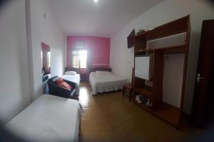 a hotel room with two beds and a couch at Hotel Guarakessaba in Guaraqueçaba
