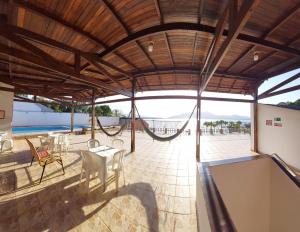 a pavilion with a table and chairs and a pool at Hotel Guarakessaba in Guaraqueçaba