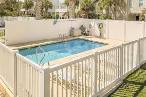 a pool on a deck with a white fence at Crescent Beach 3 Bedroom with Pool, Across the Street from Ocean in Myrtle Beach