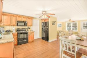a kitchen with a black refrigerator and a table at Crescent Beach 3 Bedroom with Pool, Across the Street from Ocean in Myrtle Beach