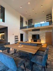 a dining room with a wooden table and blue chairs at Haus am Akazienweg in Steinberg an der Rabnitz