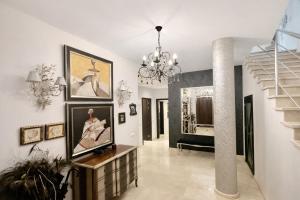 a hallway with paintings on the walls and a chandelier at Sonia Home in Córdoba