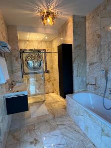 a bathroom with a tub and a shower and a sink at Haus am Akazienweg in Steinberg an der Rabnitz +30 photos
