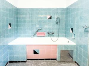 a bathroom with a tub with pink and blue tiles at Villa Acereto by Interhome in Nassereith