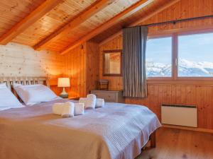 a bedroom with a bed and a large window at Chalet La Balance by Interhome in Nendaz