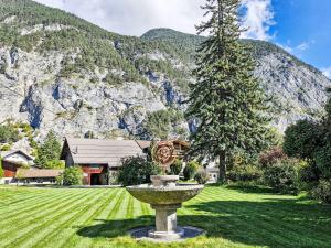 a fountain in the middle of a yard with a mountain at Villa Acereto by Interhome in Nassereith