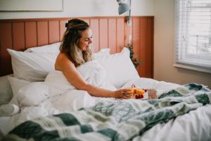 a woman is sitting in bed with a present at Hazel House Ballarat in Wendouree