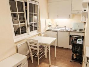 a small kitchen with a white table and chairs at Apartment Studio Turmalin by Interhome in Leukerbad