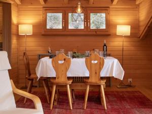 a dining room with a table and two chairs at Apartment Ker Eol by Interhome in Villars-sur-Ollon