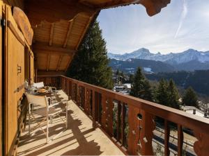 a balcony with a table and chairs and mountains at Apartment Ker Eol by Interhome in Villars-sur-Ollon