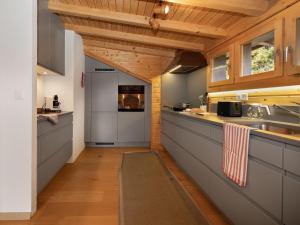 an open kitchen with wooden ceilings and wooden counters at Apartment Ker Eol by Interhome in Villars-sur-Ollon +32 photos