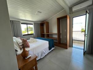 a bedroom with a white bed and a balcony at Casa Prado in Prado