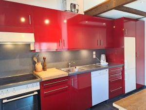 a kitchen with red cabinets and a sink at Apartment Le Sporting by Interhome in Champex