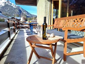 a bottle of wine sitting on a table on a porch at Apartment Le Sporting by Interhome in Champex