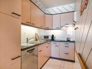 a kitchen with white cabinets and a sink at Apartment Trondjhem with seaview by Interhome in Bruges