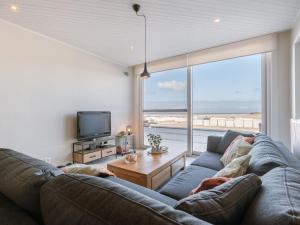 a living room with a couch and a large window at Apartment Trondjhem with seaview by Interhome in Bruges