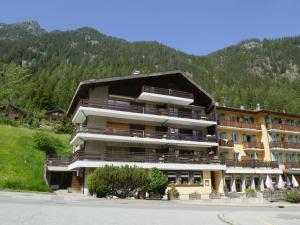 a large building with balconies and a mountain at Apartment Le Sporting by Interhome in Champex