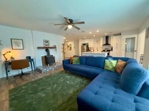 a living room with a blue couch and a fireplace at 5 Star Stay Large Remodeled Modern 4BR Near UNT and TWU Sleeps 10 in Denton