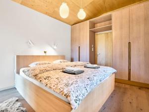 a bedroom with a large bed and wooden cabinets at Chalet Popcorn by Interhome in Abertamy