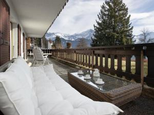a patio with white pillows on a balcony with mountains at Apartment Regina D1 by Interhome in Arveyes