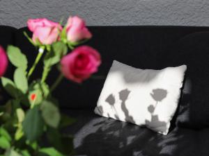 a black couch with a white pillow and roses at Apartment Regina D1 by Interhome in Arveyes +50 photos
