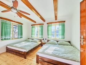two beds in a room with windows at Villa Švýcarka by Interhome in Mladé Buky