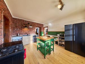 a kitchen with a green island in a brick wall at Villa Švýcarka by Interhome in Mladé Buky