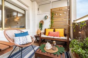 a patio with a bench and chairs on a balcony at Terraza con encanto Parking Piscina Portaventura in Salou