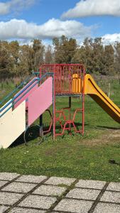 a playground with a slide in the grass at Casa Vacanze Palidoro Il Plumbaco in Palidoro
