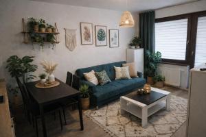 a living room with a blue couch and a table at Bootanica Apartament Piła in Piła