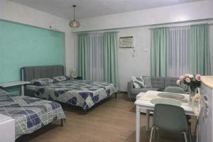 a hotel room with two beds and a living room at J & F Homestay - Cavite, Philippines in Trece Martires