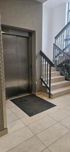 a metal garage door in a building with stairs at Bootanica Apartament Piła in Piła