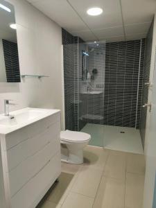 a bathroom with a toilet and a shower and a sink at Albir Beach & Sea Apt in Albir +21 photos