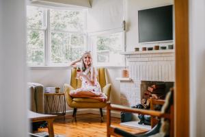 a woman sitting in a chair in a living room at Hazel House Ballarat in Wendouree