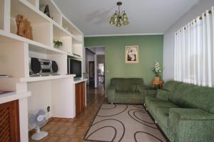 sala de estar con paredes verdes y sofá en Casa Temporada GRATÃO 06 min dos parques Thermas, en Olímpia