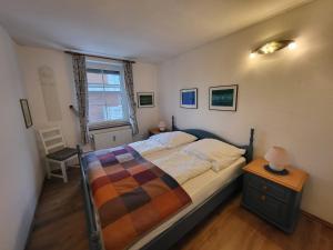 a bedroom with a bed and a table and a window at Haus Achter de Kark in Krummhörn