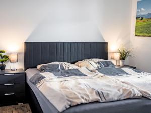 a large bed with a black headboard in a bedroom at Apartment Alpenlodge Breitenberg by Interhome in Lechbruck