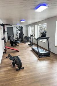 a gym with several treadmills and exercise bikes at Apartment Alpenlodge Breitenberg by Interhome in Lechbruck +15 photos