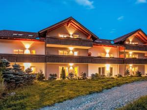 a large house with lights on the side of it at Apartment Alpenlodge Breitenberg by Interhome in Lechbruck