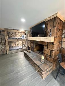 a living room with a stone fireplace with a tv at cozy cabin in Dalton