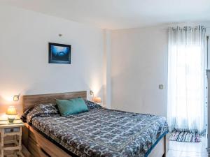 a bedroom with a bed with a blue comforter at Apartment Salina by Interhome in Llança
