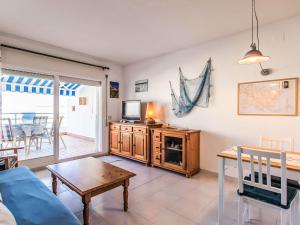 a living room with a couch and a tv and a table at Apartment Salina by Interhome in Llança