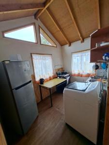 a small kitchen with a refrigerator and a table at Cabaña Hornohuinco in Llanquihue